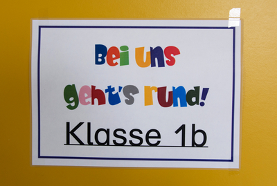 Bild: Türschild mit der Aufschrift "Bei uns geht's rund! Klasse 1b"